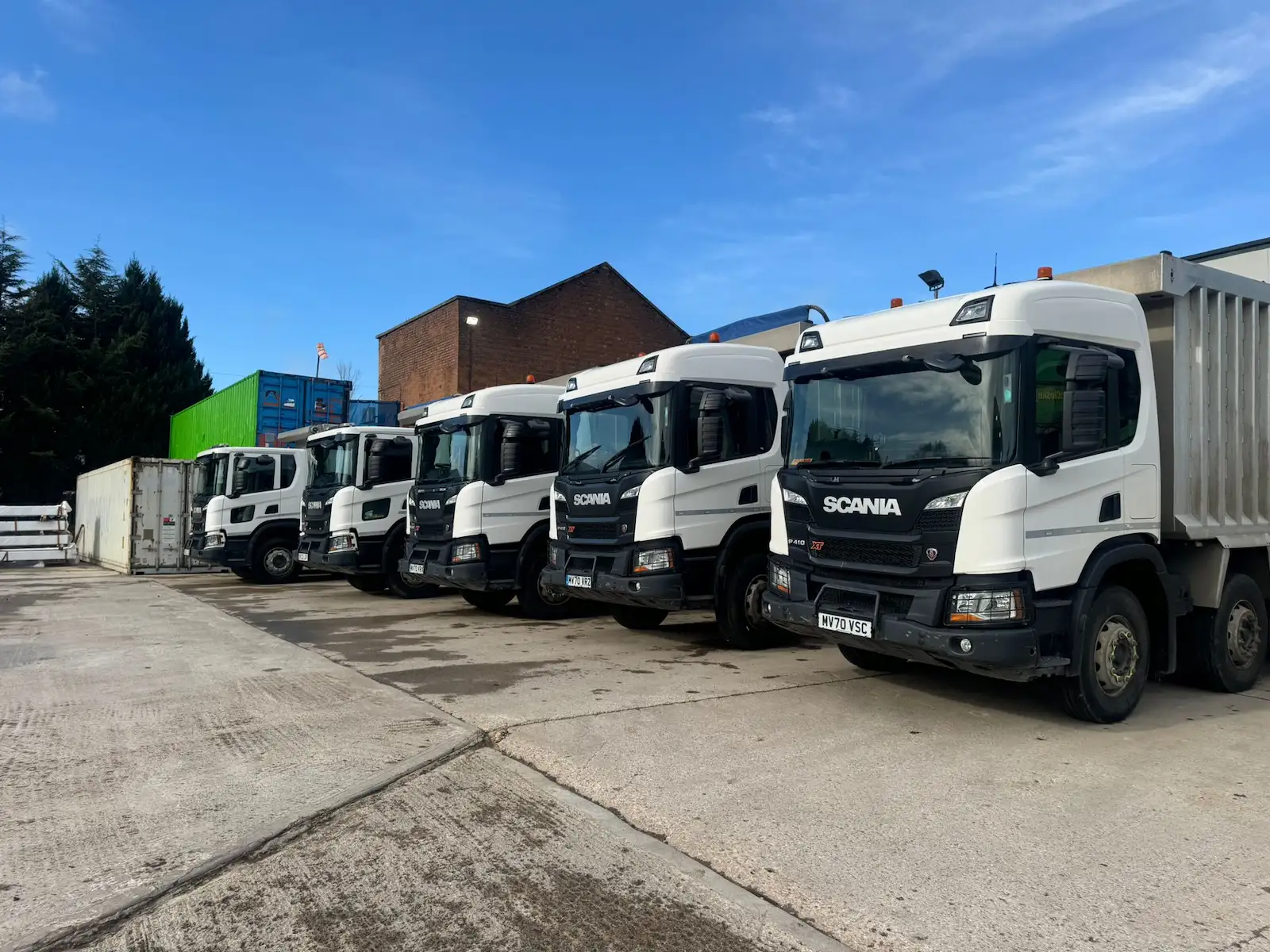 Fleet of heavy-duty haulage trucks supporting bulk earthworks and large-scale material transport on a commercial construction project.vators and dump trucks carrying out bulk earthworks and drainage installation on a large-scale civil engineering infrastructure project.