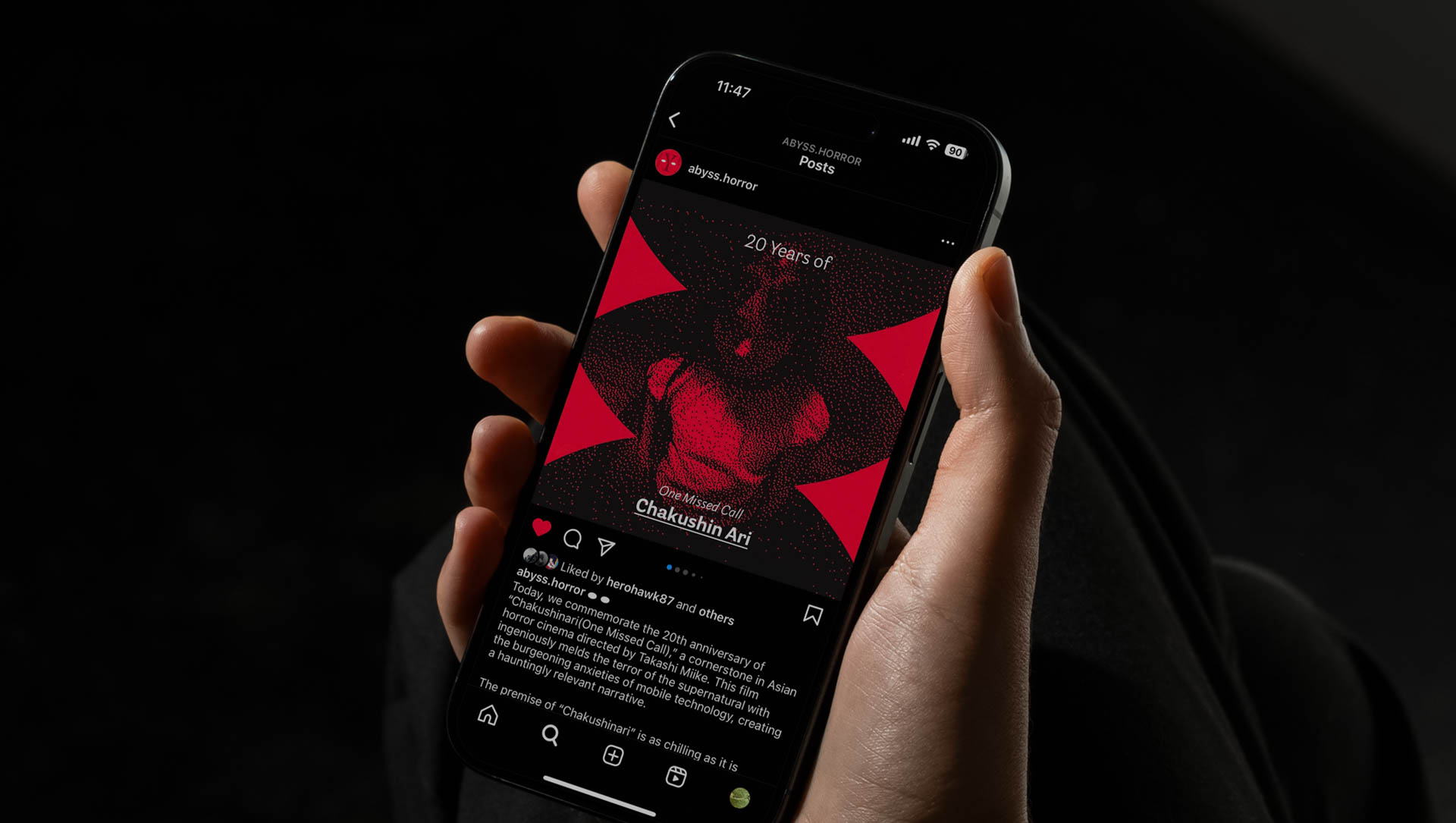A hand holds a black smartphone displaying a red and black image on its screen. The image shows a person with dark hair, wearing a red top, against a red and black geometric background. The phone’s screen also shows text including “20 Years of” and “Chushtin Ai”. The bottom of the screen displays social media icons and text including “@abyss.horror” and “@chushtin.ai”. The time displayed on the phone is 11:47.