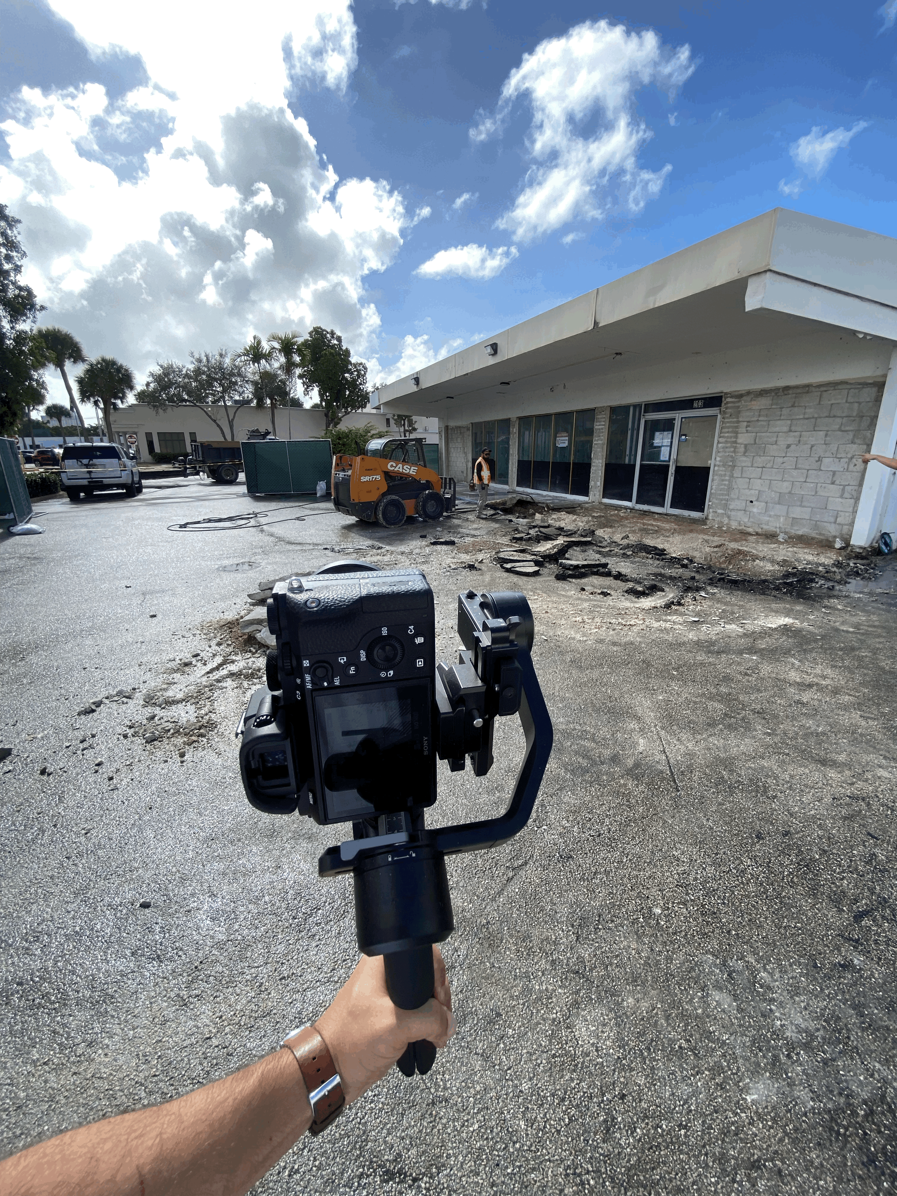 Three individuals gathered around a table, engaged in discussion while examining a laptop.