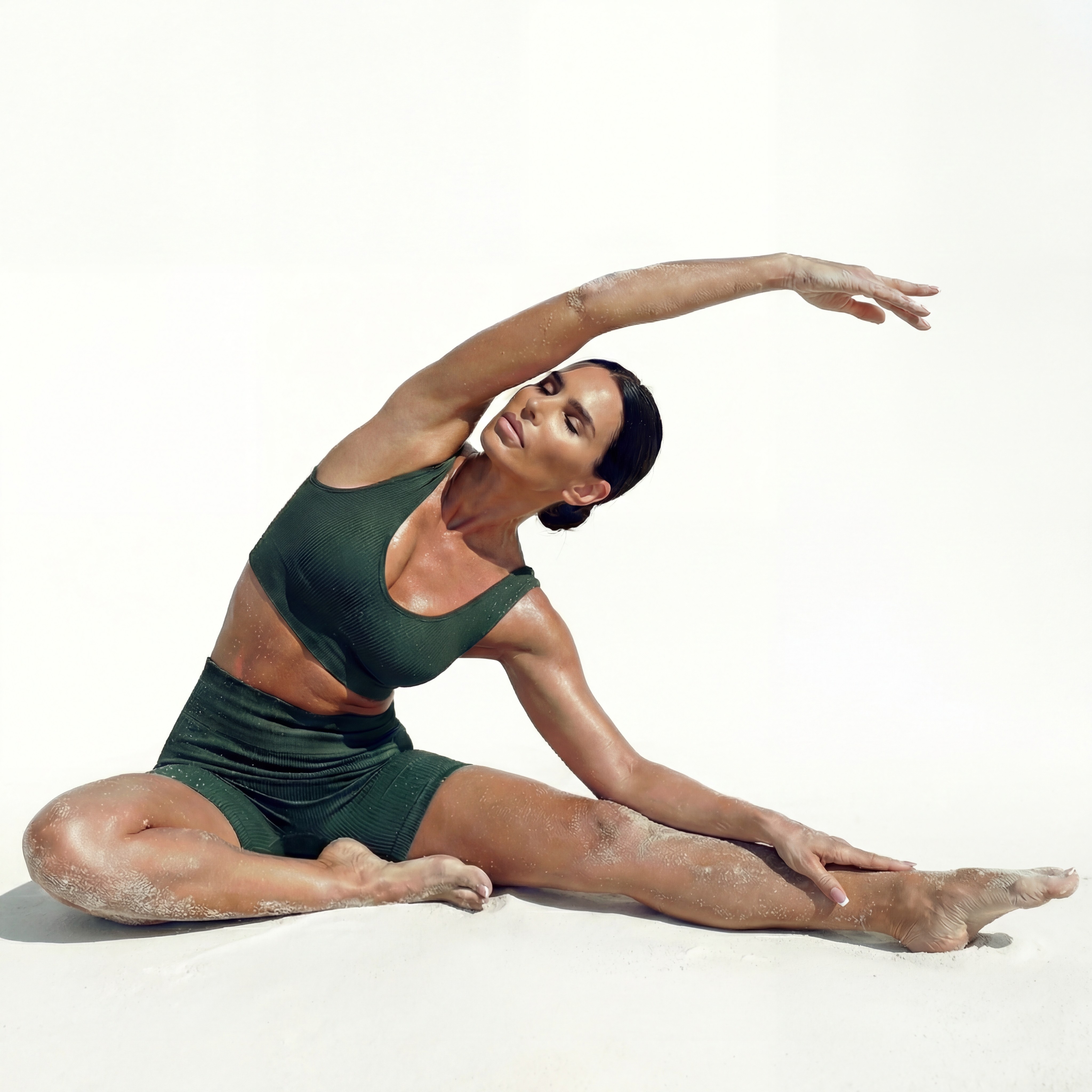 A woman doing a seated side stretch while looking up with closed eyes