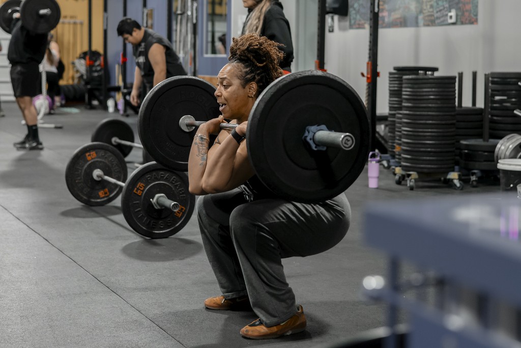 young lady squatting with barbell