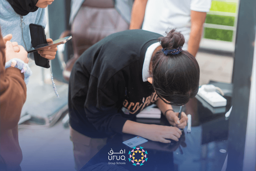 استاذة تساعد الطلبة في حملة انتخاب برلمان الصف