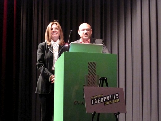 a man and a woman talking at a green stand on the Ideopolis exhibition
