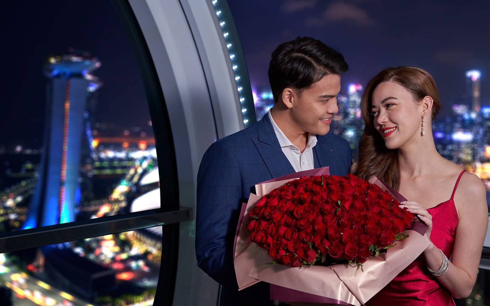 Couple dining in a capsule on the Singapore Flyer, celebrating Valentine's Day with city skyline views.