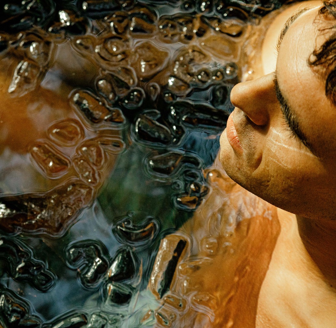 Person holding ice cubes during ice bath at Nômade Tulum, Mexico.