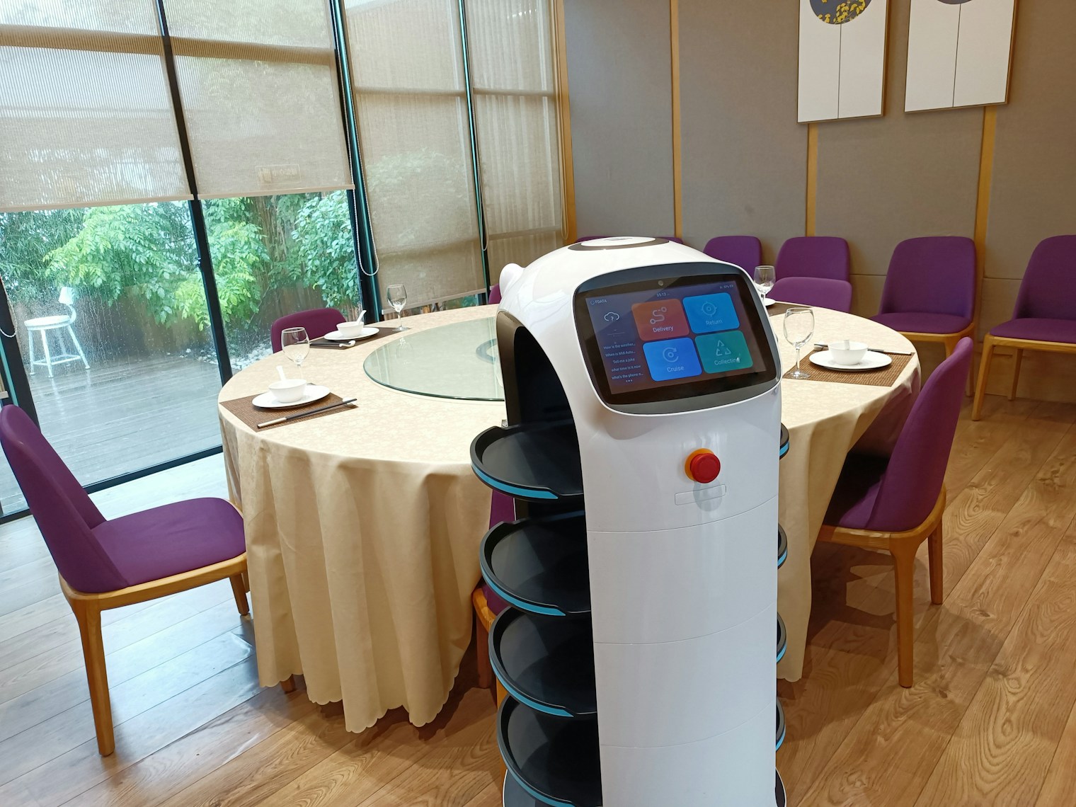 An autonomous service robot delivering food inside a restaurant dining room