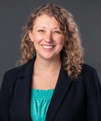 Headshot of Dr. Erin Kempe in a teal blouse and black blazer