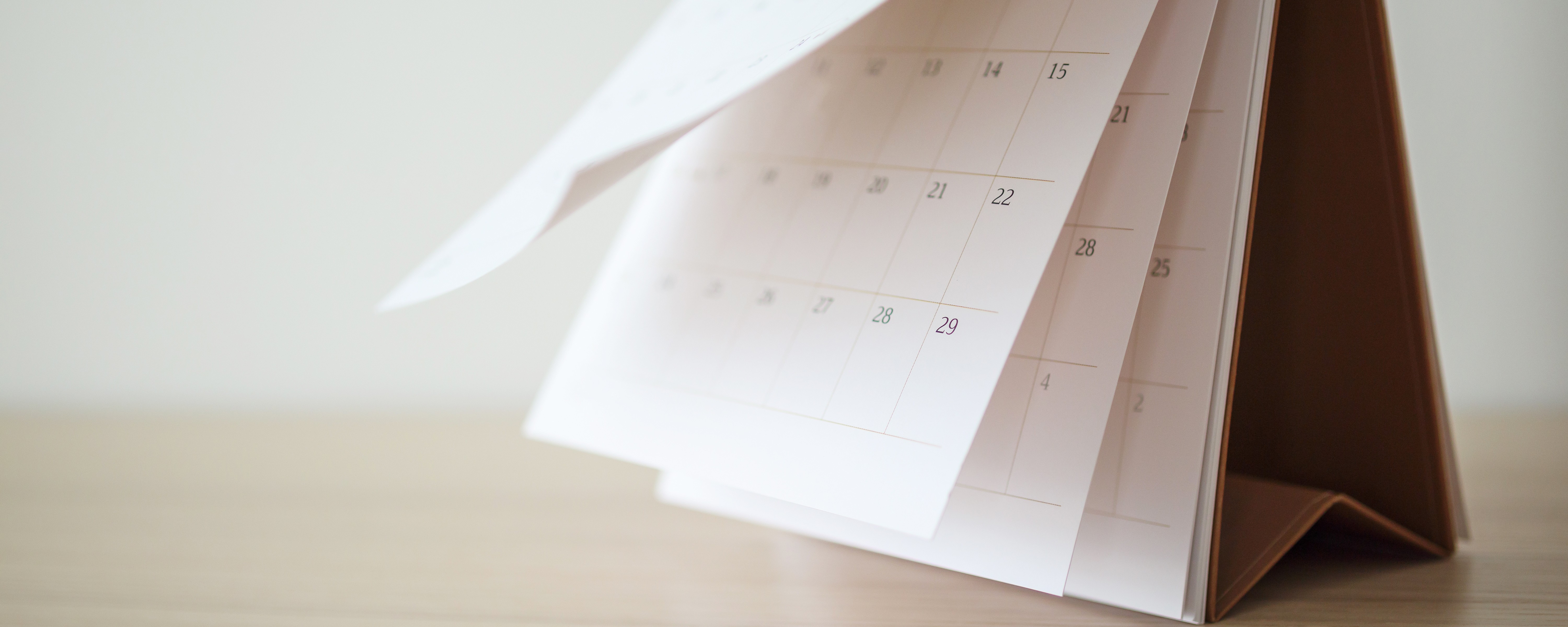 Close-up of a desk calendar with pages turning, illustrating future dates for spot and forward FX transactions.