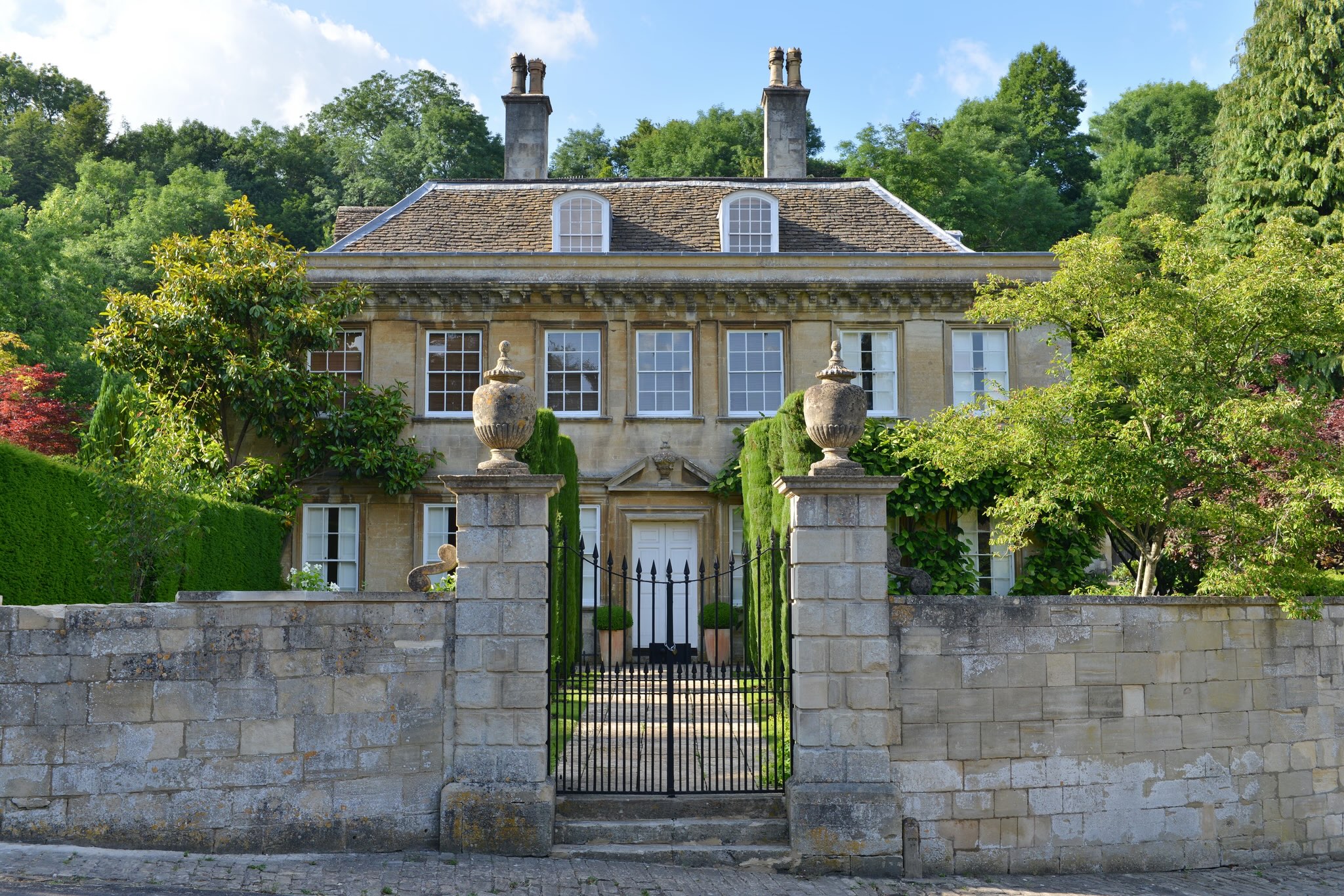 Georgian Manor House with Wrought Iron Gates Representing Family Legacy and Heritage