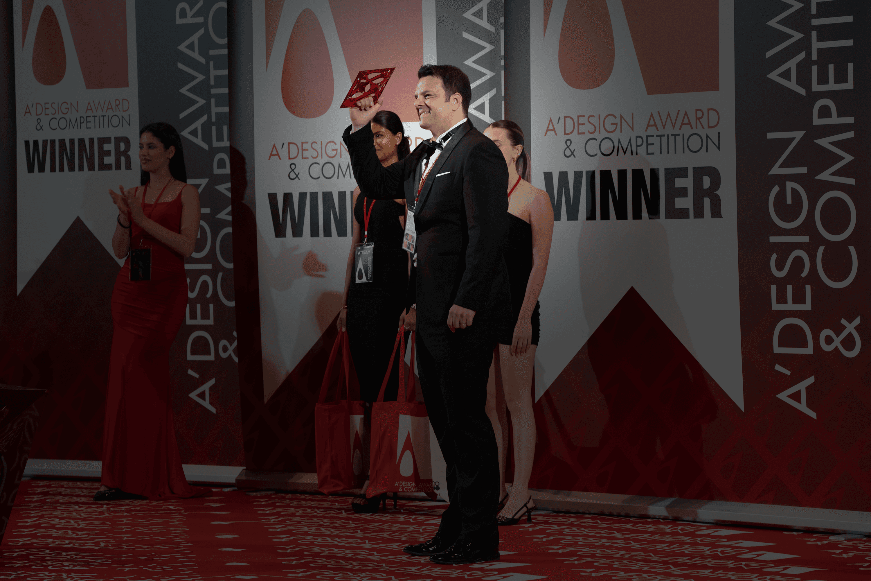 Three people sitting on a couch in a room looking at mobile devices