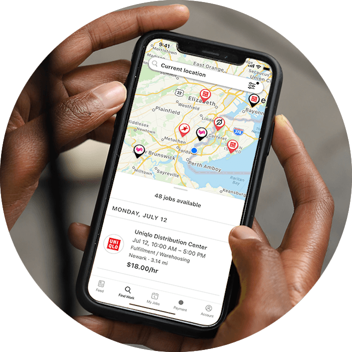 A person holding a mobile phone displaying an application showing jobs