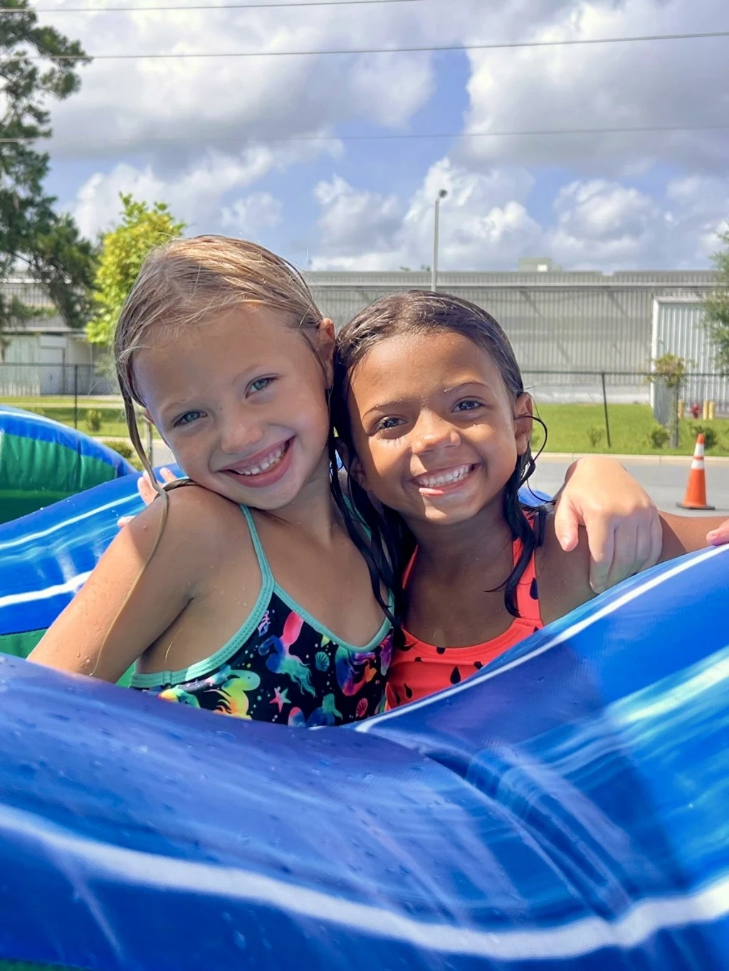 Camp children sitting and listening to firemen at a firehouse visit.