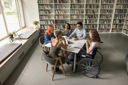 Researchers and patient in wheelchair participate in teamwork