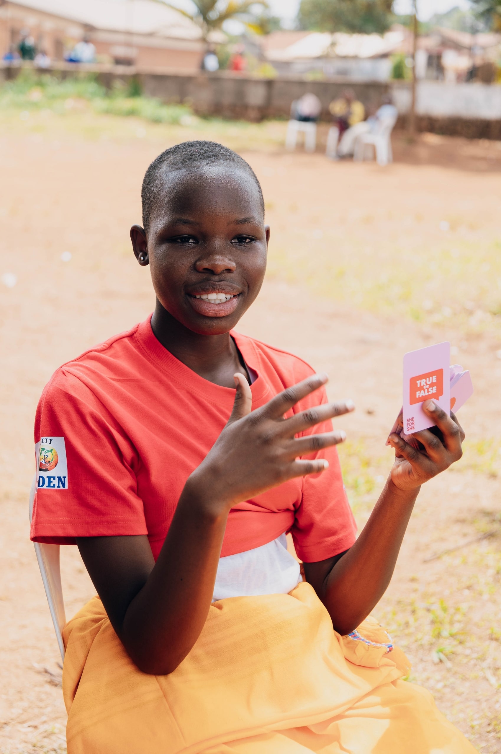 Girl holding an educational card stock designed by She For She for menstrual health education.