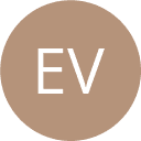 a young man wearing glasses standing in front of a mountain