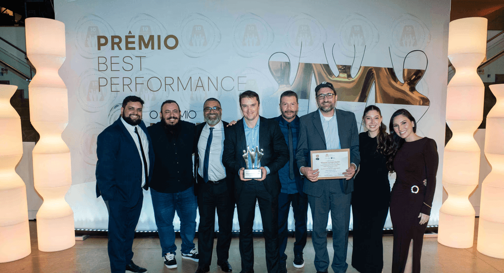 Executivos da Data Agrin posando com troféu e certificado no palco do Prêmio Best Performance 2025