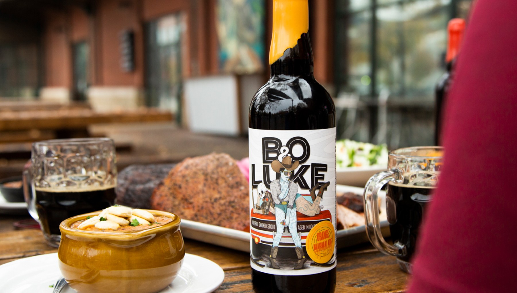 Image of the Against the Grain Bo & Luke bottle with food