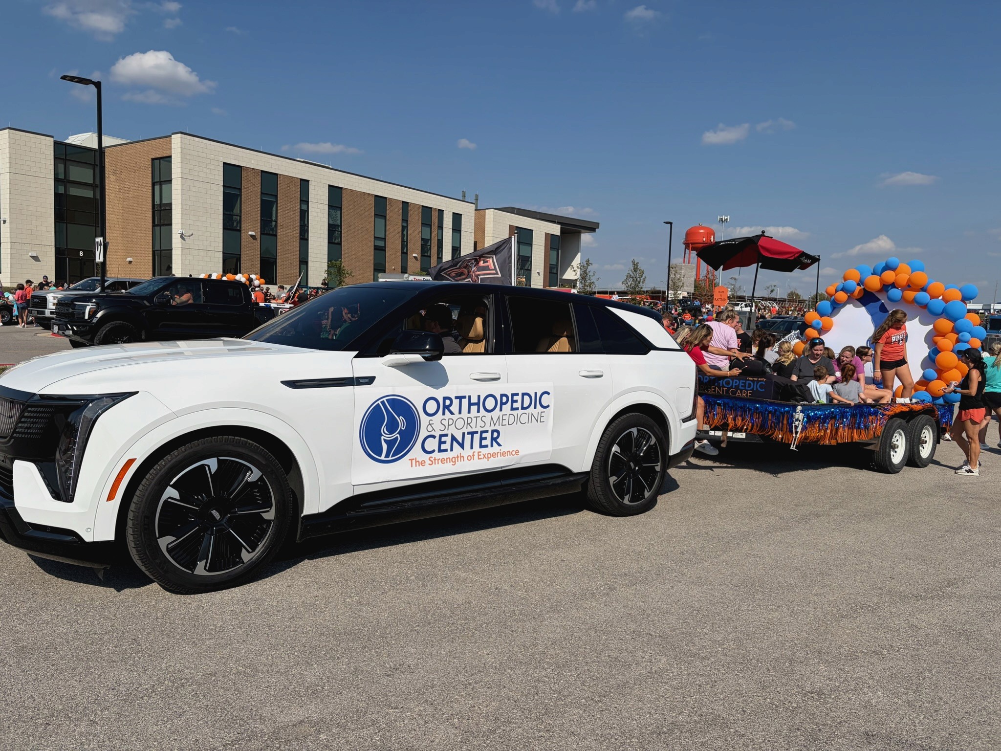 OSMC branded Cadillac pulling the Orthopedic and Sports Medicine Center parade float through Platte City for a community event