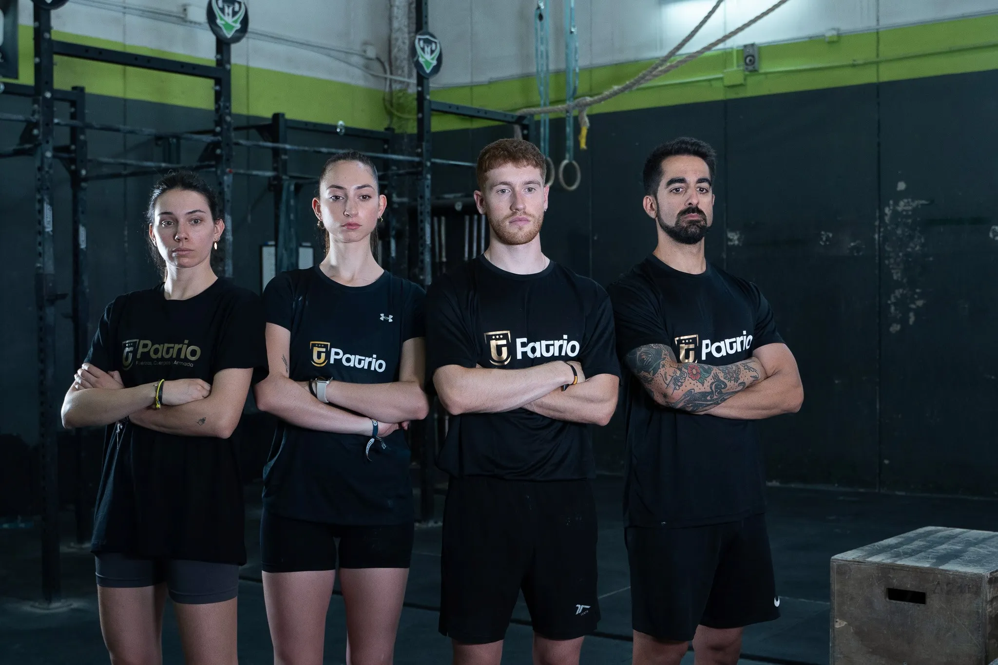 Medieval stone castle wall and tower with orange roofs against a pale sky.