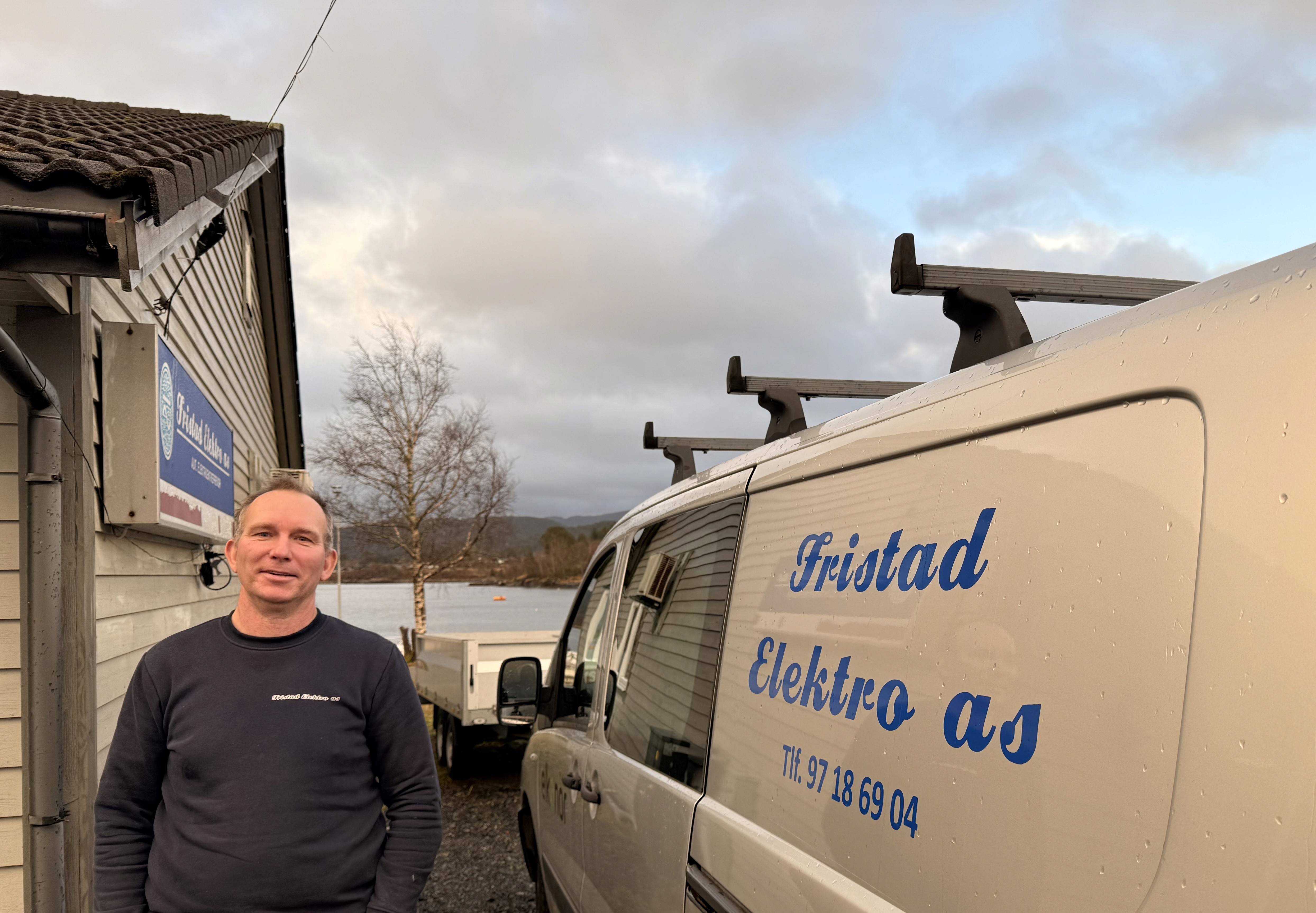 Kjetil Fristad foran bil, hus og sjøutsikt