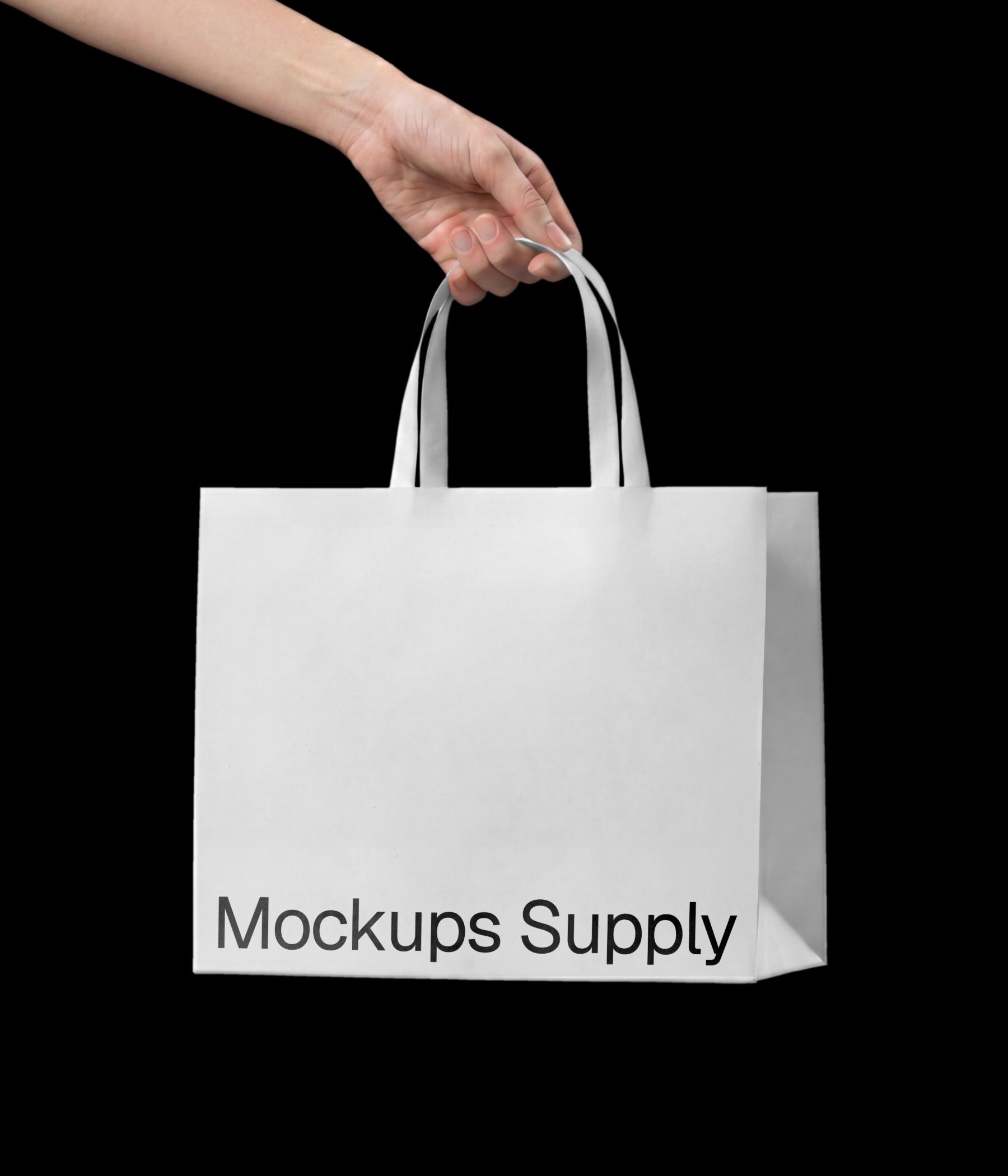 Hand holding paper bag mockup with ribbon handle styled as luxury jewelry packaging download PSD