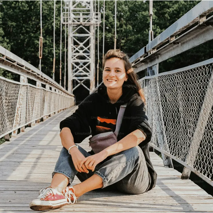 Woman sitting on a footbridge.