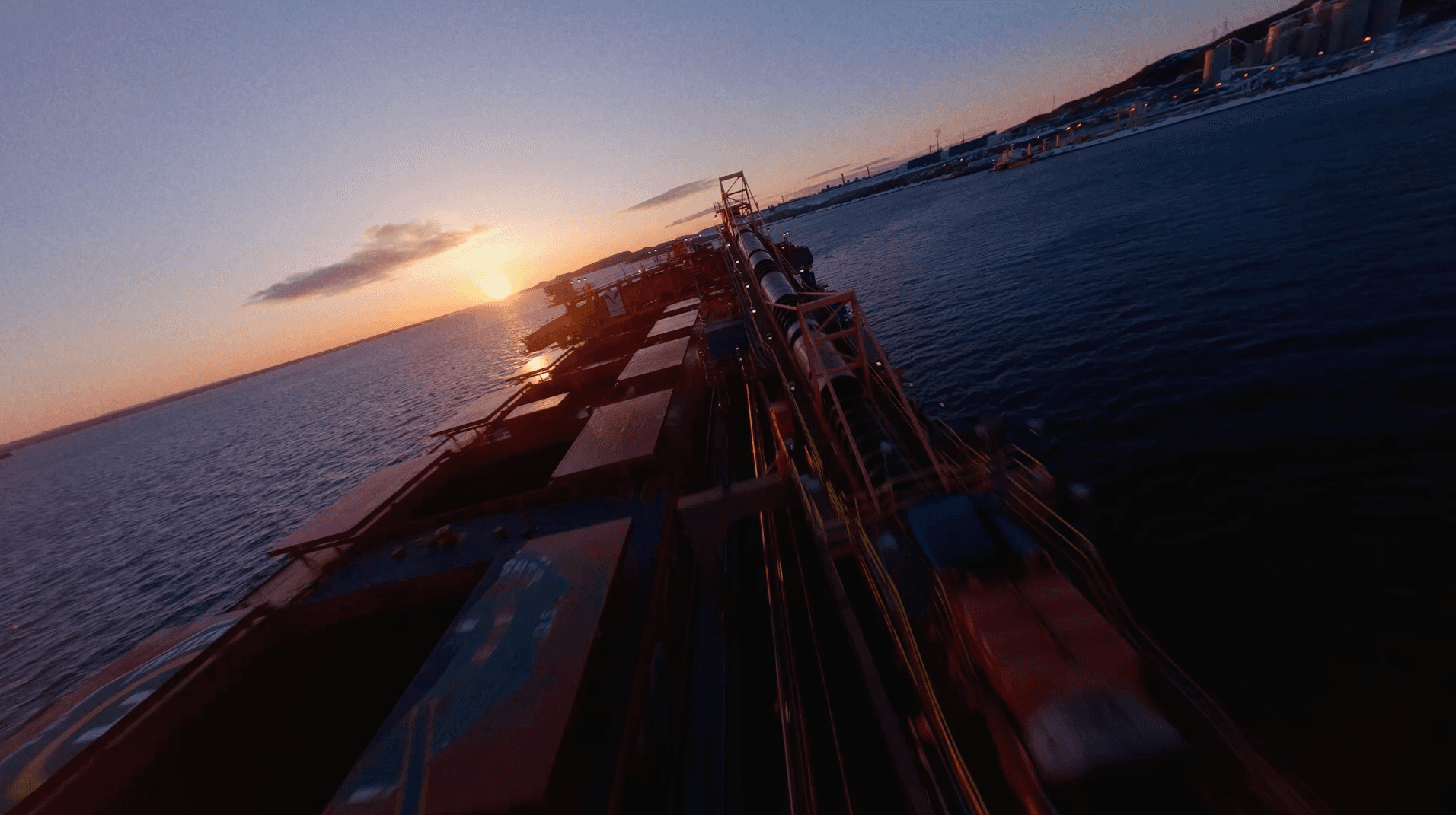 large cargo ship on the water at sunset