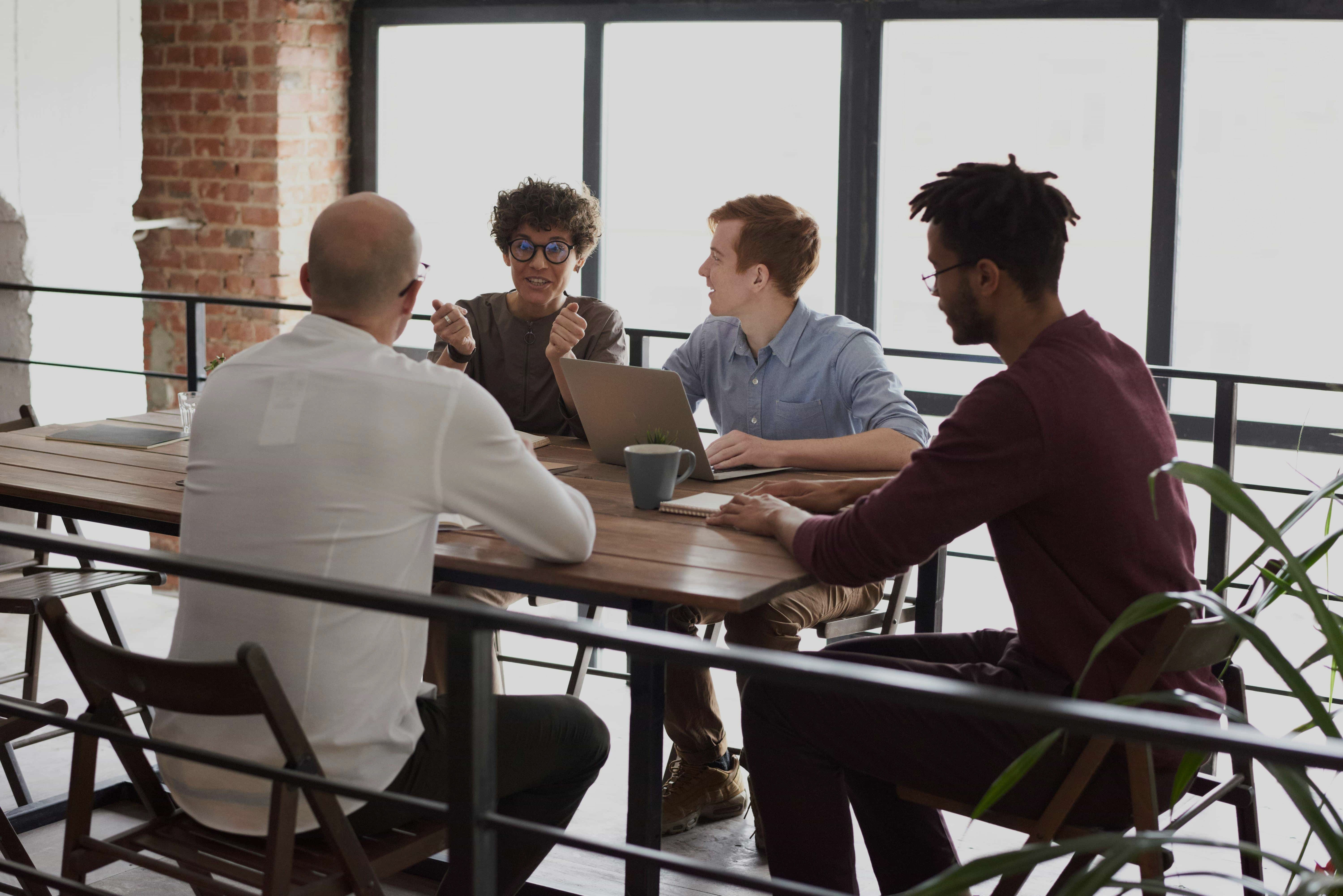 Four colleagues collaborating around a wooden table.