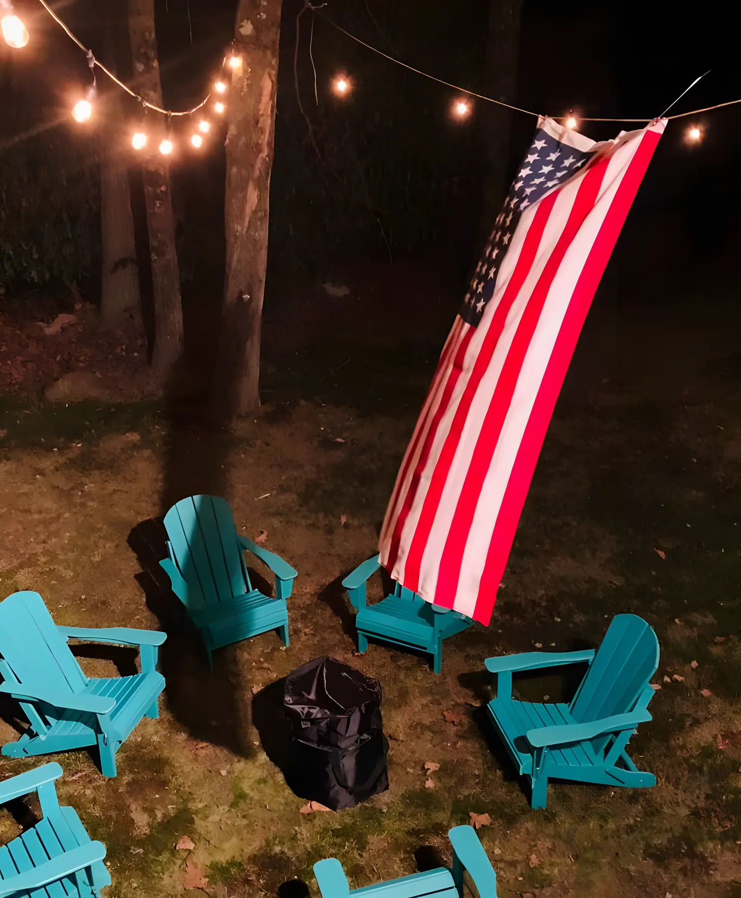 Fire pit under string lights at night with teal chairs at DeerPath Crossing, Lake Harmony, PA