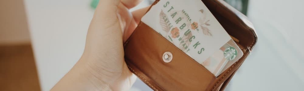 person holding brown leather coin purse