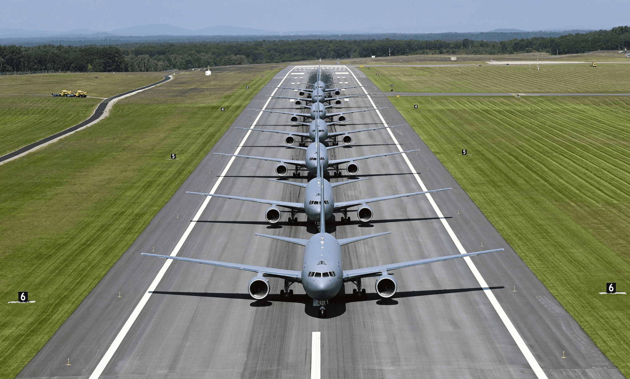 A line of U.S. Air Force KC-46A Pegasus tankers taxiing nose to tail on a runway