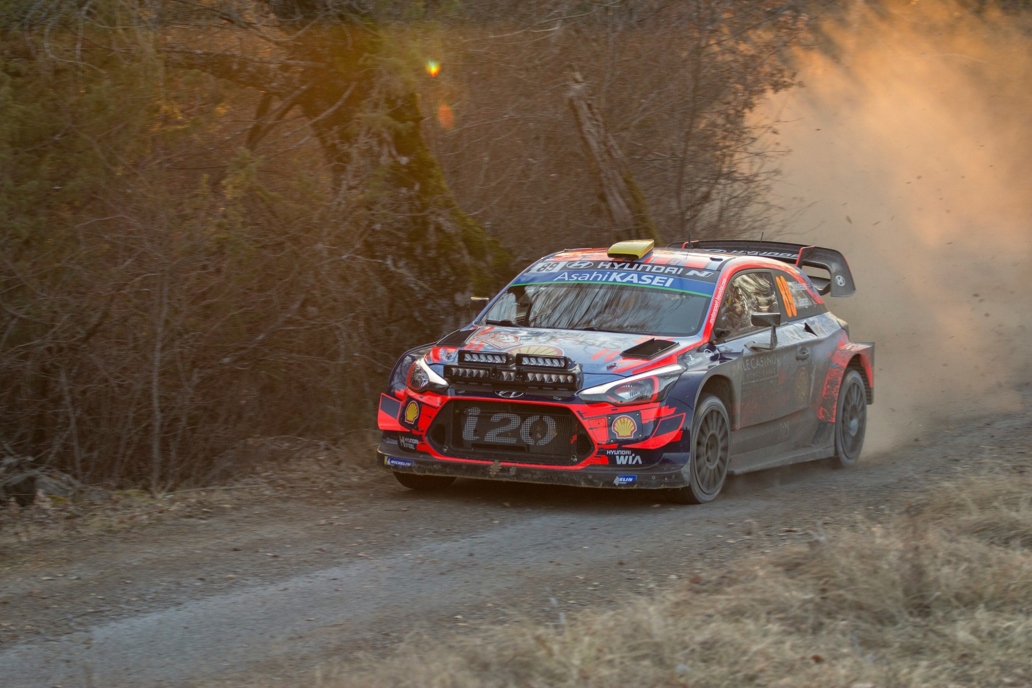 blue and red rally car on dirt road during daytime