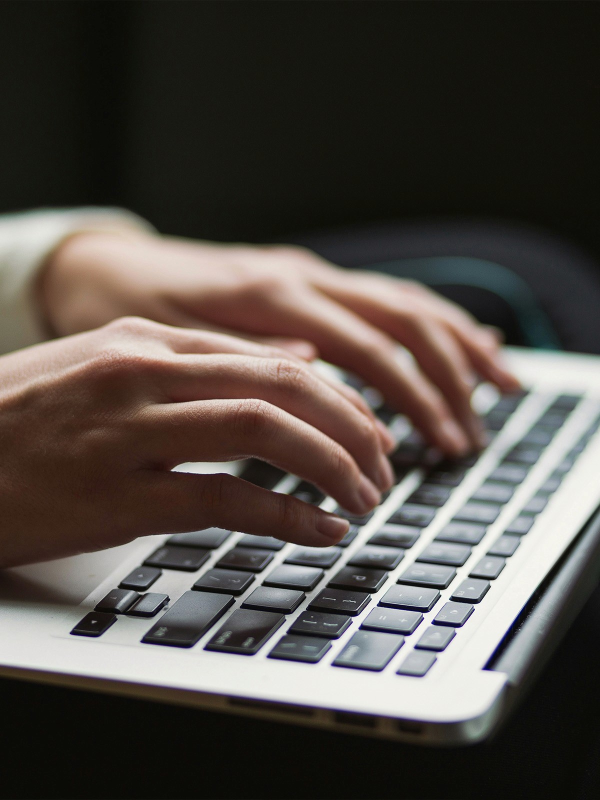 Close up of hands typing on laptop