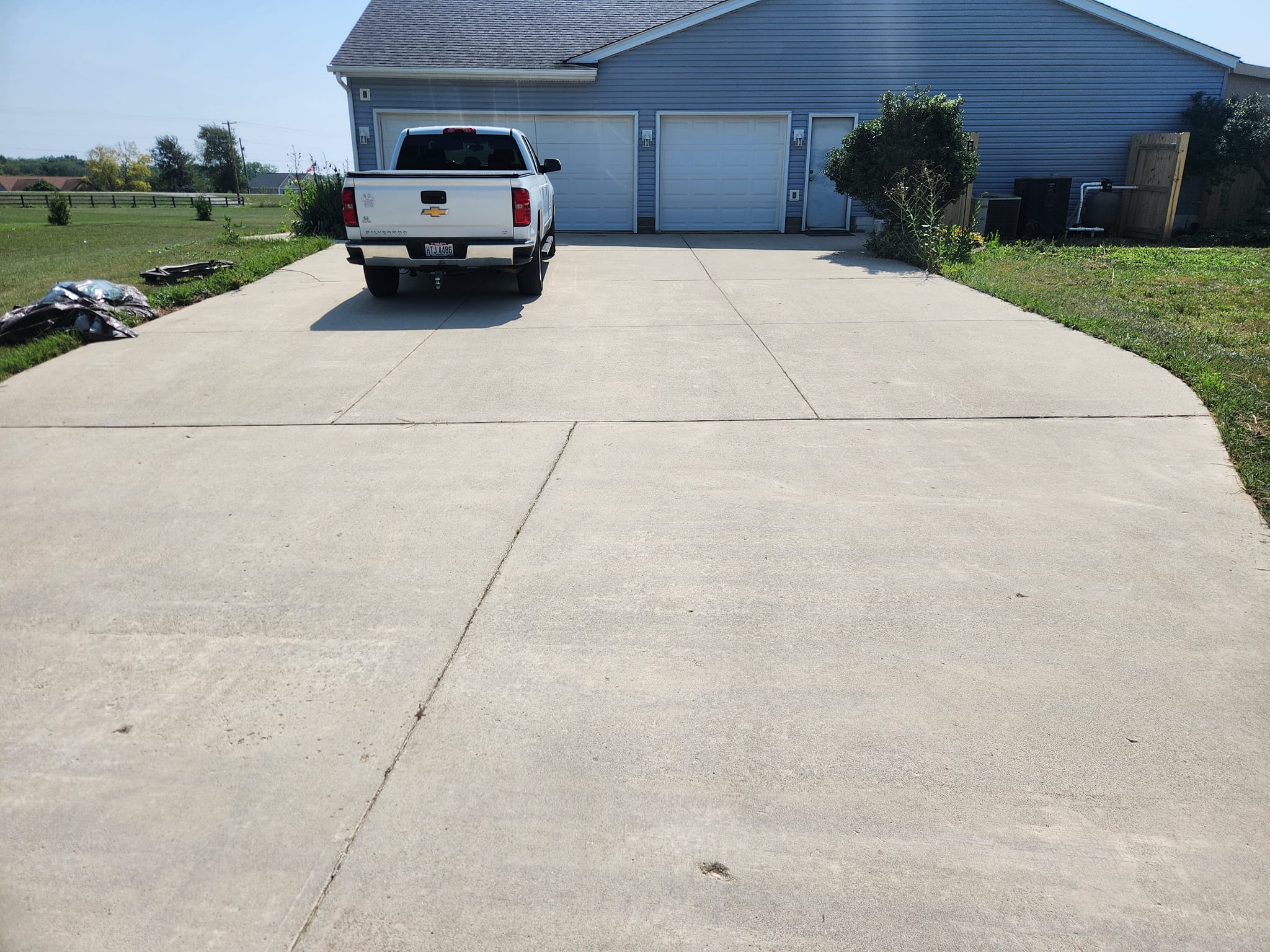Modern kitchen with a wooden dining table, white chairs, and a hanging light fixture above.