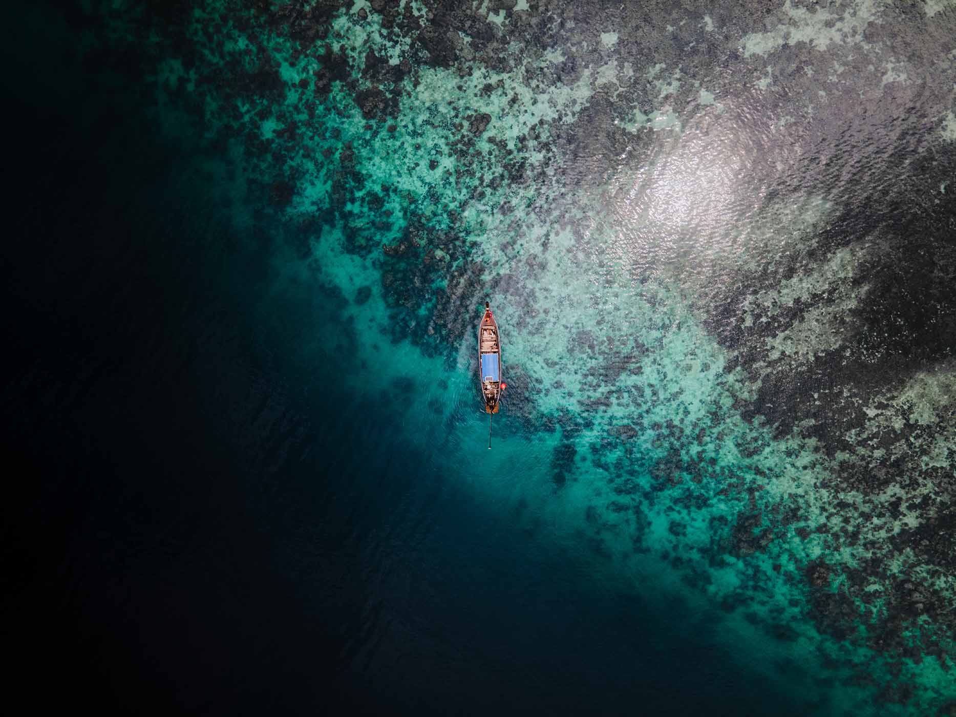 Drone view of a small fishing boat on the water at Koh Phi Phi Island, Thailand.