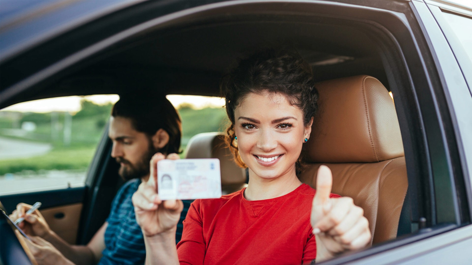 Kursantka z instruktorem siedzący w samochodzie podczas jazdy.
