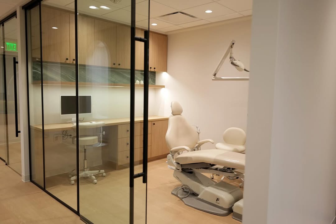 Private consultation room at Alinea Orthodontics clinic with wood furniture and minimalist interior design.