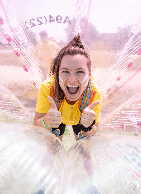 Women in a inflatable ball smiling with her thumbs up.