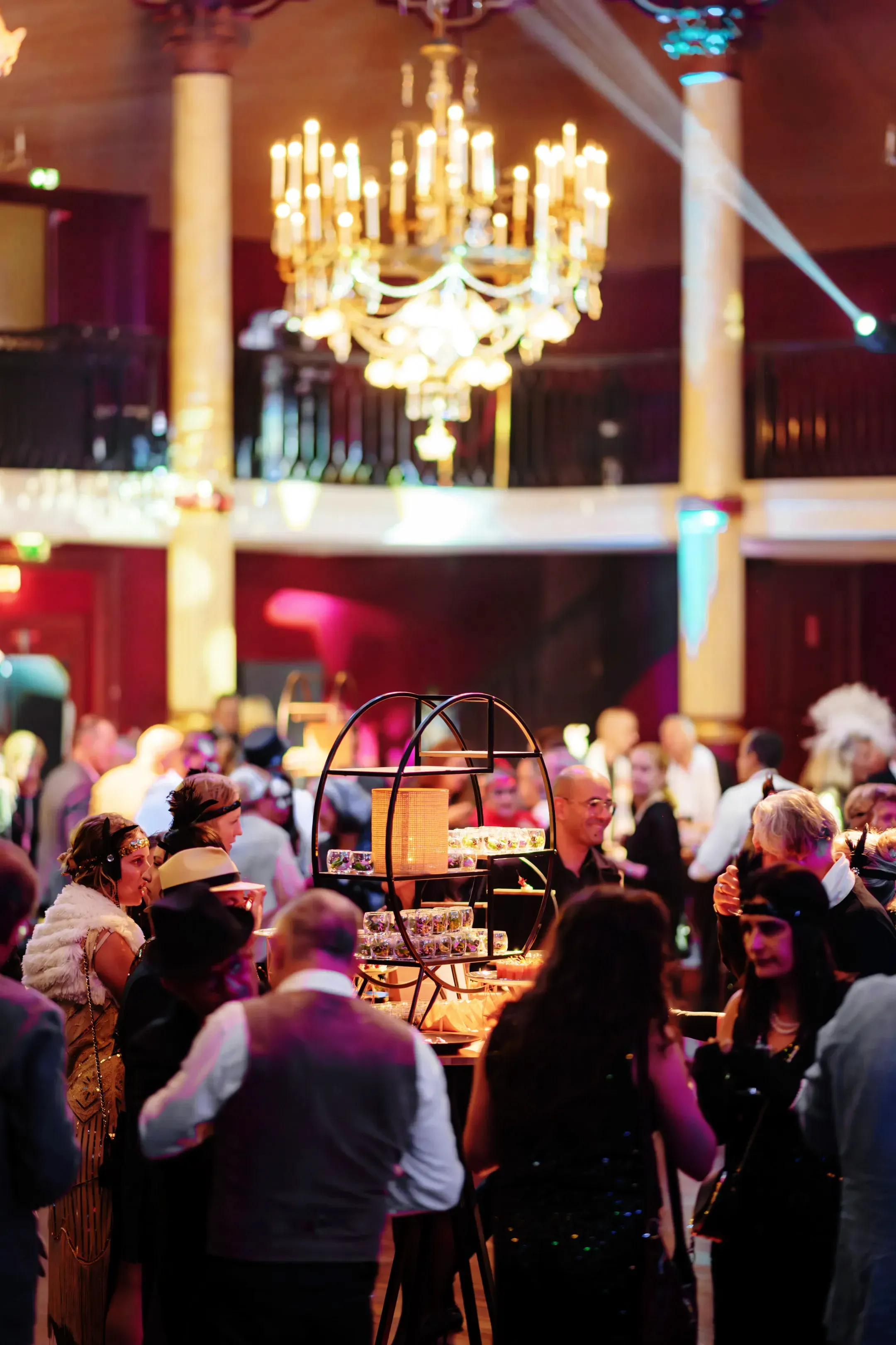Vue d’ensemble d’une soirée de gala avec buffet et invités en tenue années 30 dans une ambiance festive