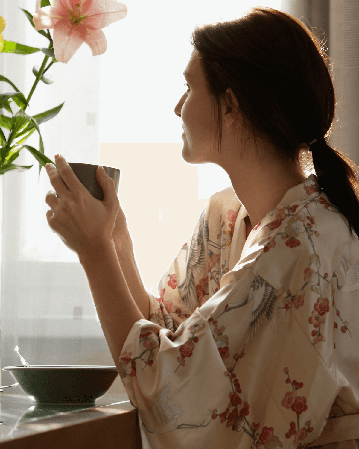 Woman drinking coffee and looking out a window