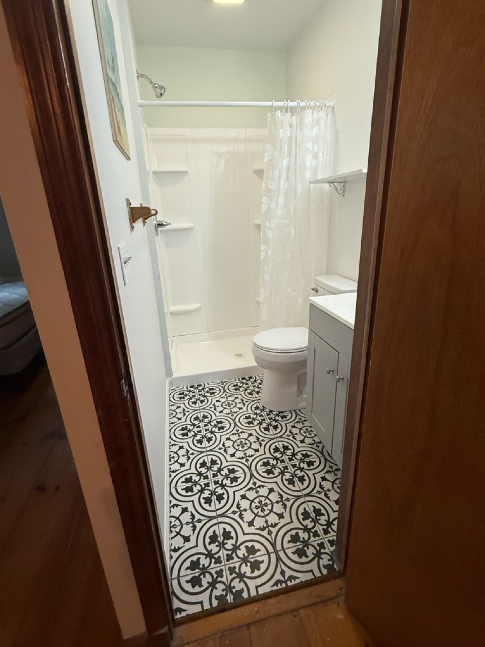Completed bathroom seen from the doorway with the new shower and patterned tile floor