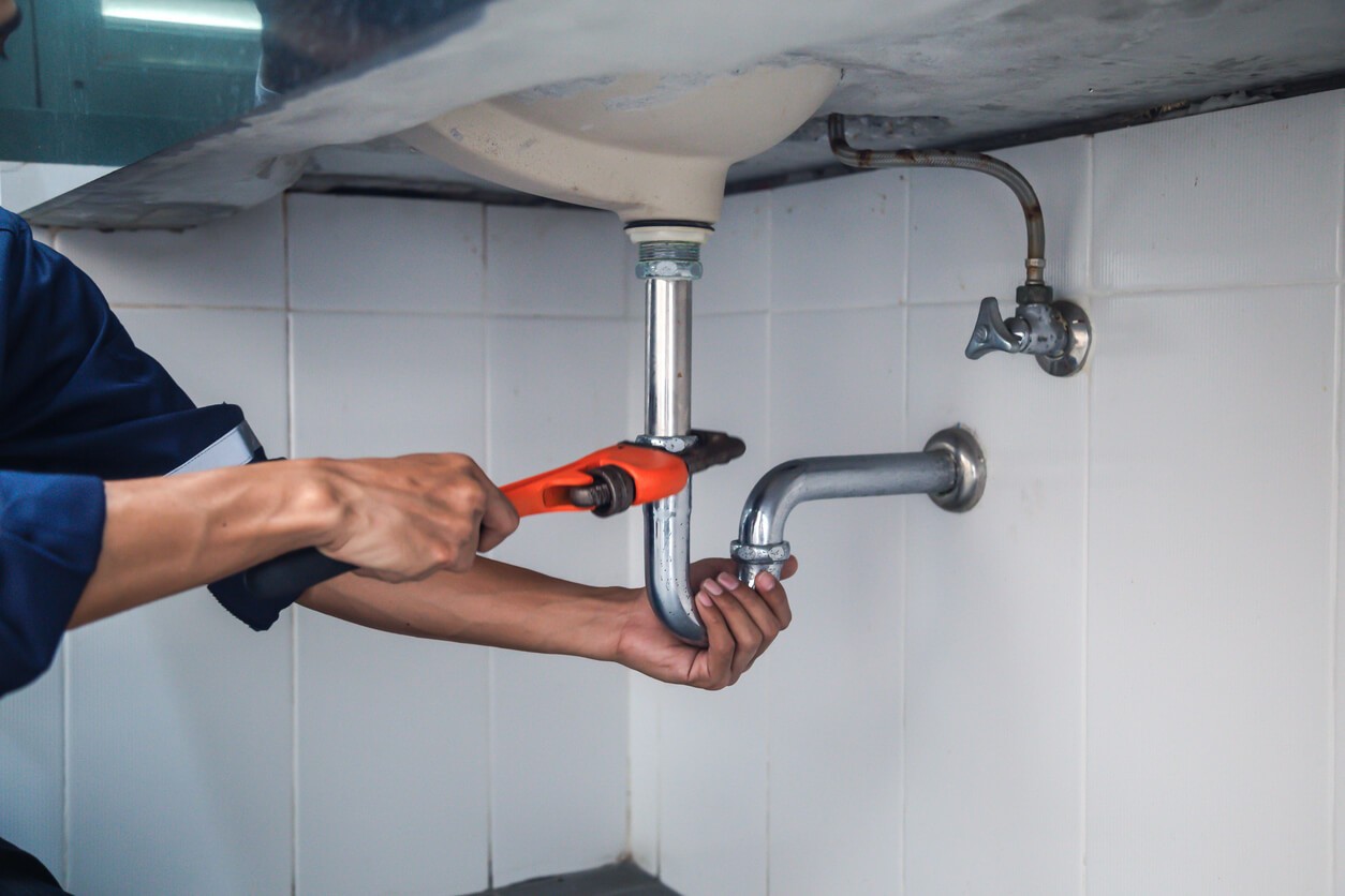 Plumber using a wrench to fix a pipe