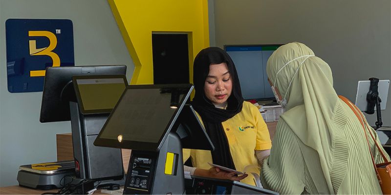 Jurujual wanita Big POS sedang menerangkan tentang sistem Big POS kepada pelanggan.