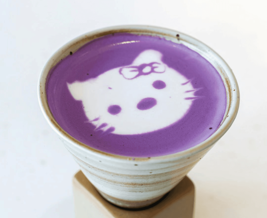 Photo of ube latte, a vibrant purple drink featuring Hello Kitty latte art