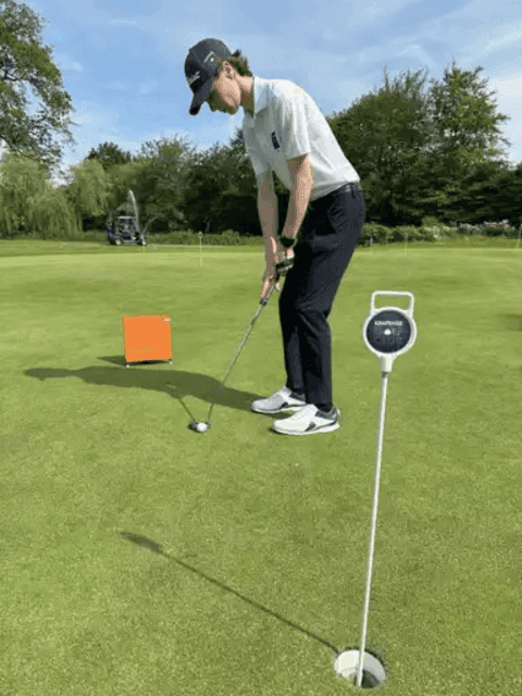 arm met golfclub en Hackmotion rond de pols