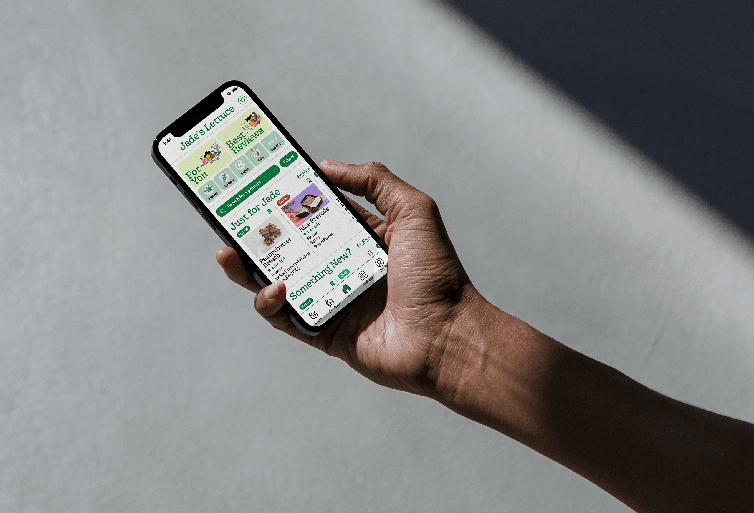 A hand holds a smartphone displaying the Jade Lettuce app. The screen shows various menu items, including "Just Add Jade," "Just Add Lettuce," "Just Add Jade Lettuce," and "Just Add Jade Lettuce." The app interface includes icons and text indicating food items and nutritional information. The background is a light gray surface with a shadow cast by the hand.
