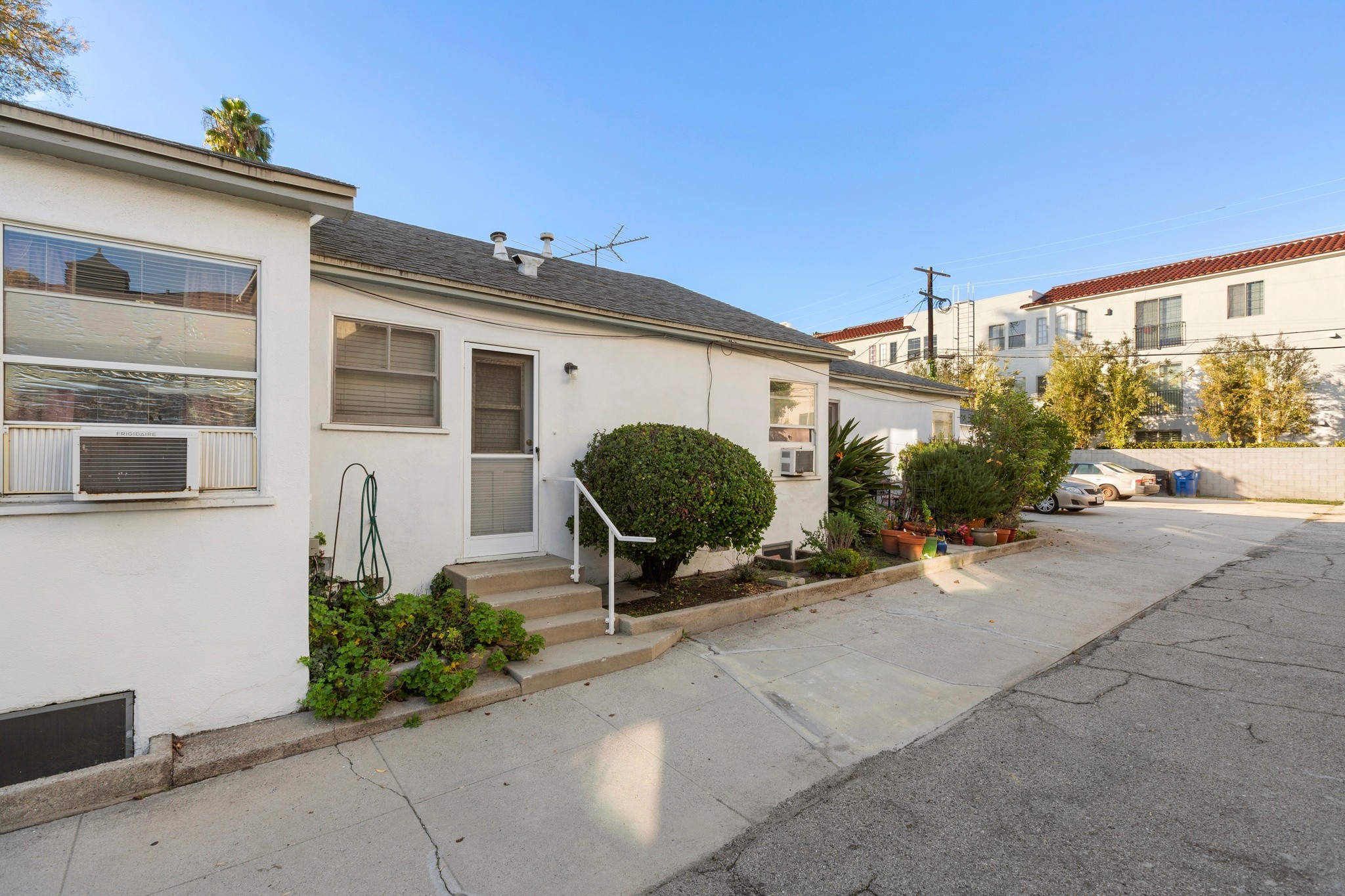 Wide exterior perspective capturing the full layout of the Toluca Lake triplex property at 10651 Whipple.