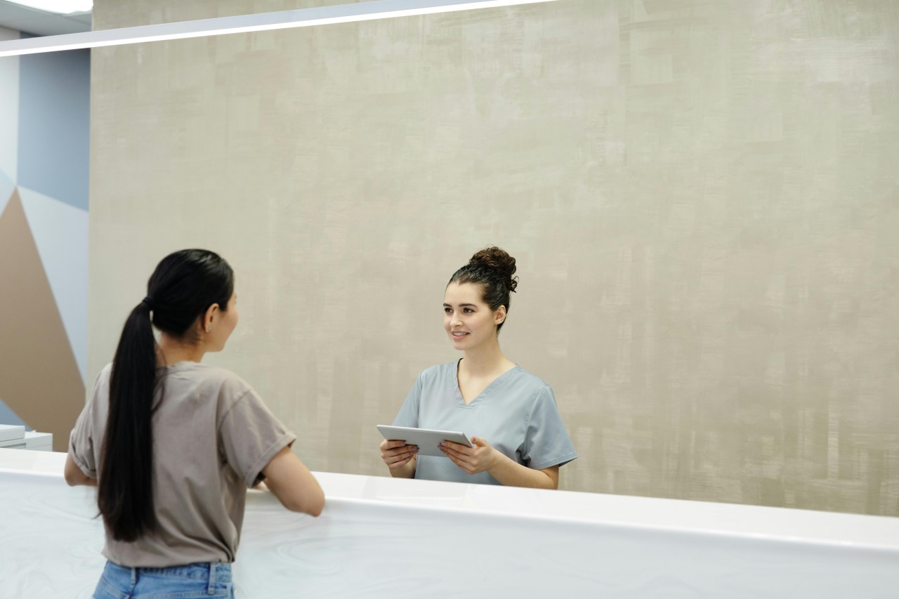 a patient talks to a receptionist