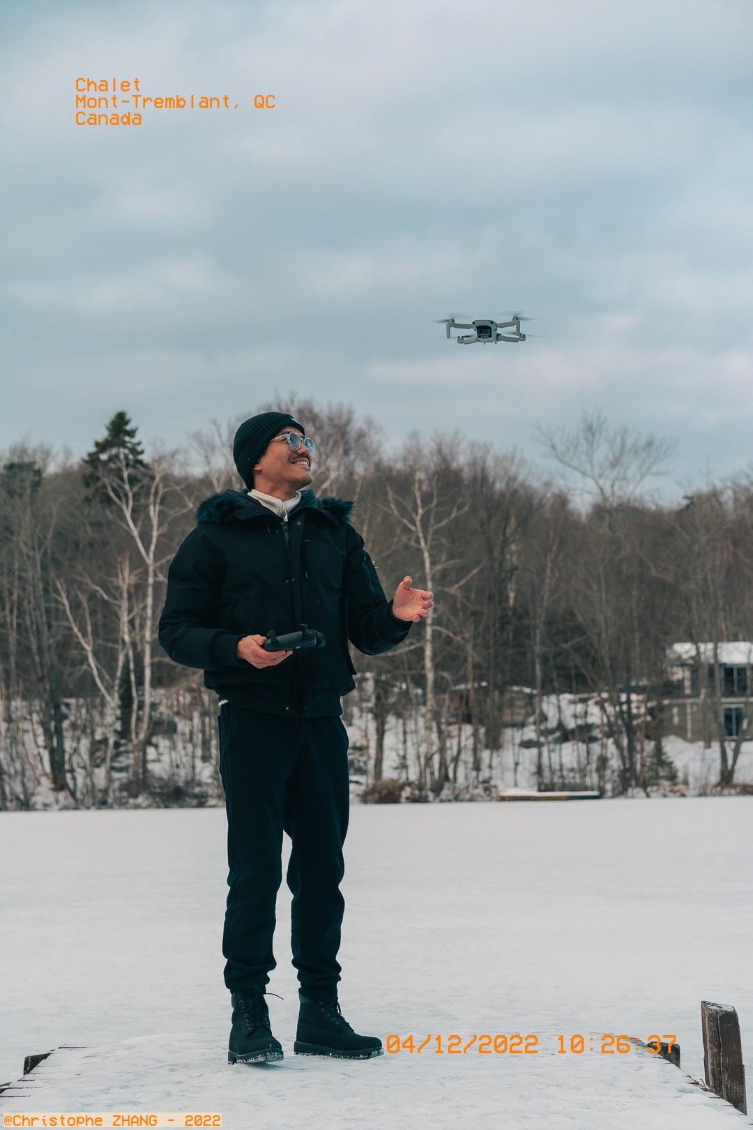 Photographe contrôlant un drone au-dessus d'un lac gelé à Mont-Tremblant.