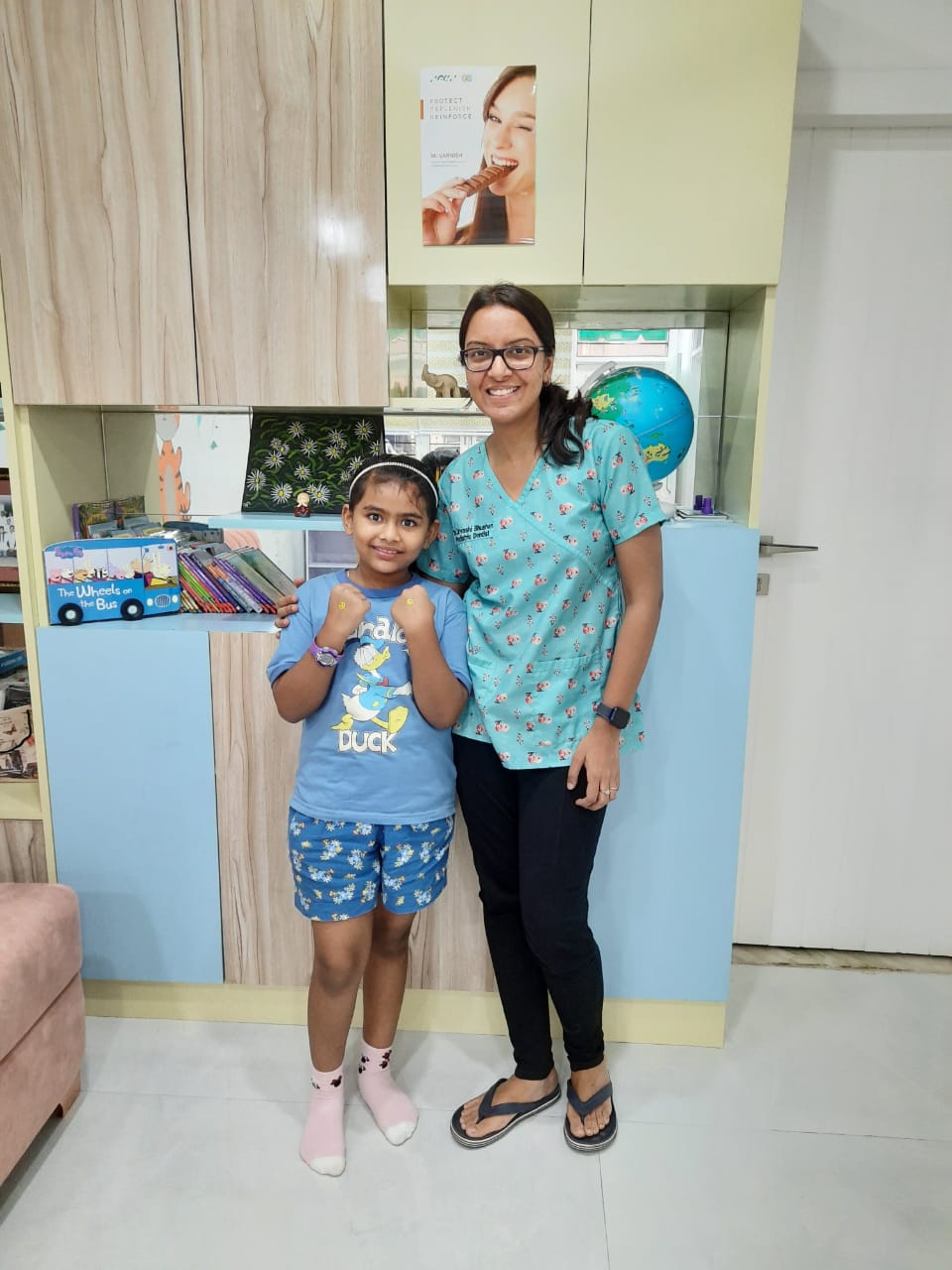 Dr. Urvashi with a smiling young patient at the clinic reception